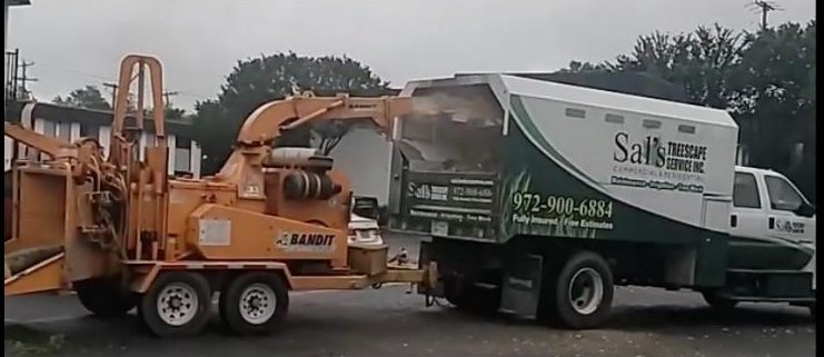 Sal's Treescape chipper truck and wood chipper on a commercial job